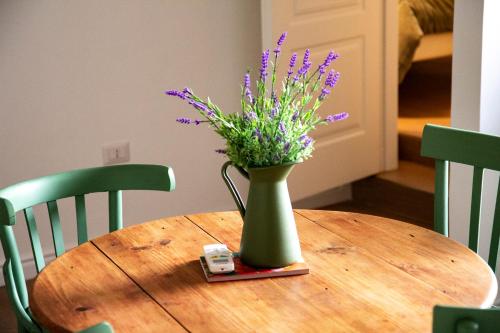 a vase with purple flowers on a wooden table at Palazzo Donnamaria in Manfredonia