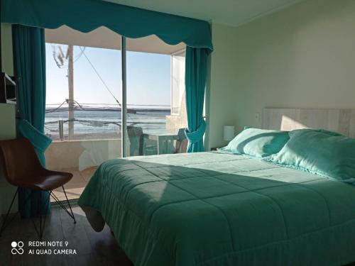 a bedroom with a bed and a view of the ocean at Depto Oceanic III La Serena in La Serena