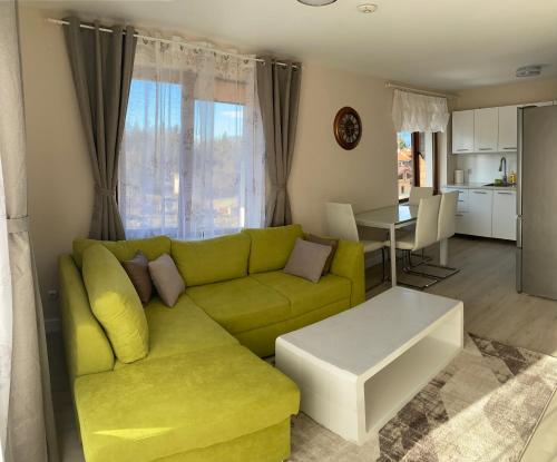 a living room with a green couch and a table at 2 bed 2 bath, 4 min walk to slope, Predela2, Bansko in Bansko