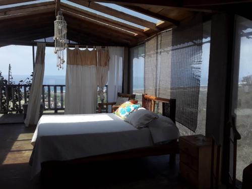 1 dormitorio con cama y ventana grande en Maremonti Vacation Rental, en Puerto López