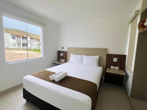 1 dormitorio con 1 cama blanca grande y ventana en DM Hoteles Asia, en Asia
