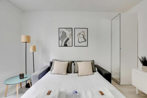 - une chambre blanche avec un lit et une table bleue dans l'établissement Magnificent studio - 2P - Ternes-Arc de Triomphe, à Paris