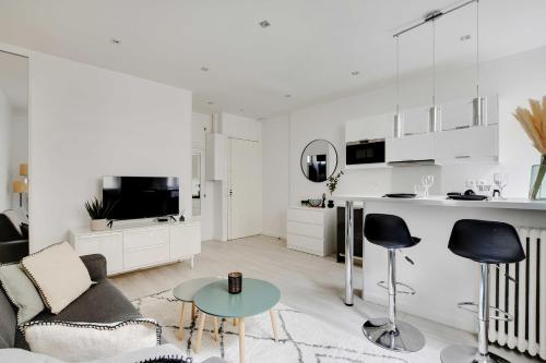 un salon blanc avec un canapé et une table dans l'établissement Magnificent studio - 2P - Ternes-Arc de Triomphe, à Paris