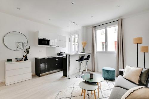 un salon blanc avec un canapé et une table dans l'établissement Magnificent studio - 2P - Ternes-Arc de Triomphe, à Paris