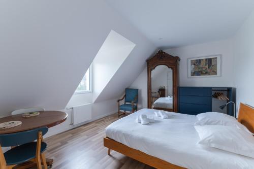 a bedroom with a bed and a table and chairs at TY KREIZH - Maison neuve avec piscine proche mer in Saint-Pabu