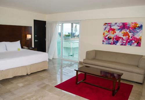 1 dormitorio con cama, sofá y mesa en Four Points by Sheraton Veracruz, en Veracruz