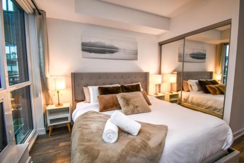 um quarto com uma grande cama branca e 2 almofadas em Sauna*King Bed*Fireplace*SmartTV em Innisfil