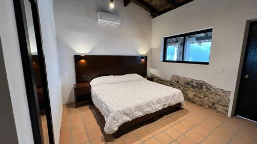 a bedroom with a bed and a window in it at La Peña Hotel Boutique & SPA in Cuetzalán del Progreso