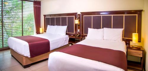 a hotel room with two beds and a window at Hotel D'Carlo Class in Arequipa
