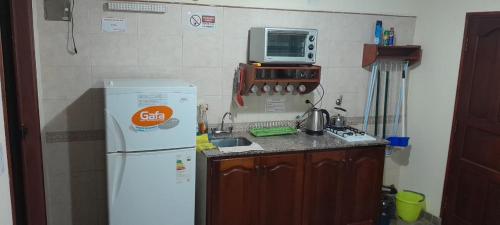 uma cozinha com um frigorífico branco e um micro-ondas em las campanitas em Paso de la Patria
