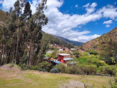 a house on a hill in a valley with mountains at casa montañista lodge & camping in Huaraz