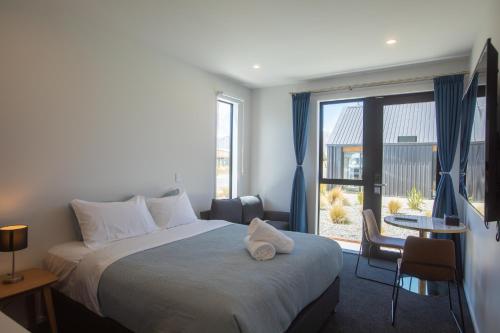 um quarto de hotel com uma cama e uma grande janela em Luminous Tekapo em Lake Tekapo