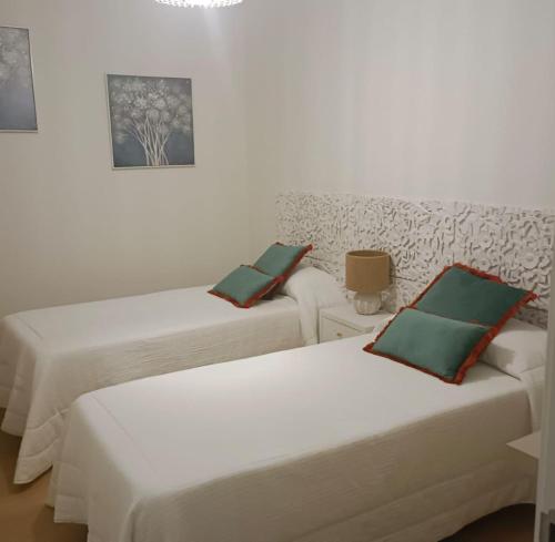 2 camas en una habitación con paredes blancas en AGAETE PARADISE, en Puerto de las Nieves