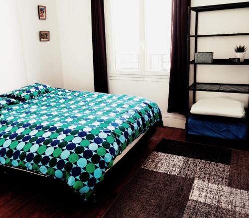um quarto com uma cama com um cobertor verde e branco em Au Cœur de Troyes - Calme et Confort em Troyes
