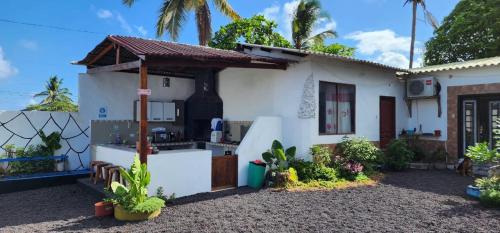 ein weißes Haus mit einer Küche im Hof in der Unterkunft HOSPEDAJE DELFIN AZUL in Puerto Villamil