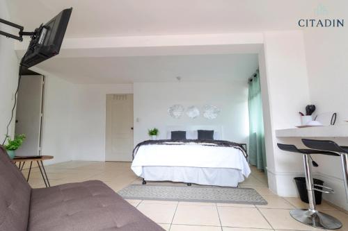 1 dormitorio con 1 cama y 1 sofá en Hotel Citadin, en Guatemala