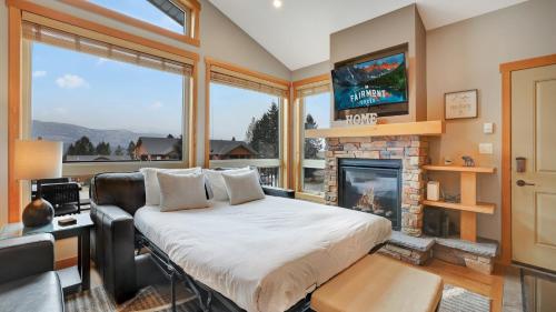 1 dormitorio con 1 cama y chimenea en The Residences at Fairmont Ridge, en Fairmont Hot Springs