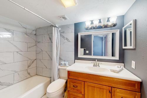 La salle de bains est pourvue d'un lavabo, de toilettes et d'une baignoire. dans l'établissement Ocean Mile B2, à Île Saint Georges