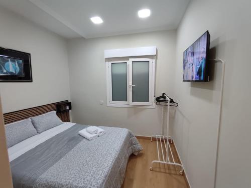 a bedroom with a bed and a flat screen tv at Apartamento en Gran Vía in Bilbao