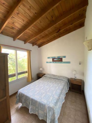 a bedroom with a bed and a large window at Complejo Refugios Marinos in Valeria del Mar