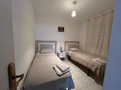 a bedroom with two beds and a lamp in it at Apartement à La Mata in Torrevieja