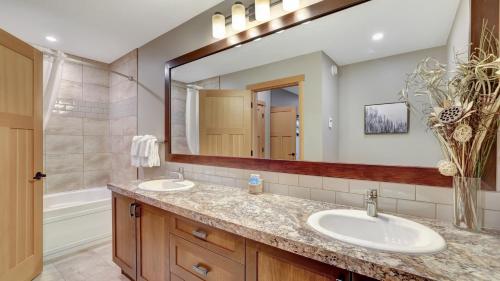 baño con 2 lavabos y espejo grande en The Residences at Fairmont Ridge, en Fairmont Hot Springs