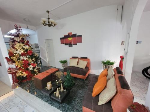 a living room with a couch and a christmas tree at Hostal Gosén in Puerto Baquerizo Moreno