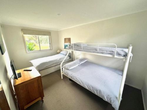 1 Schlafzimmer mit 2 Etagenbetten und einem Schreibtisch in der Unterkunft The Shack, Red Rocks in Cowes