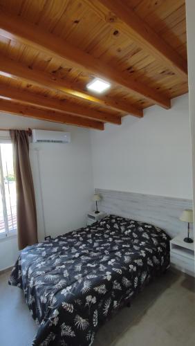 een slaapkamer met een bed met een zwart-witte deken bij Las Cañas dpto in Guaymallen
