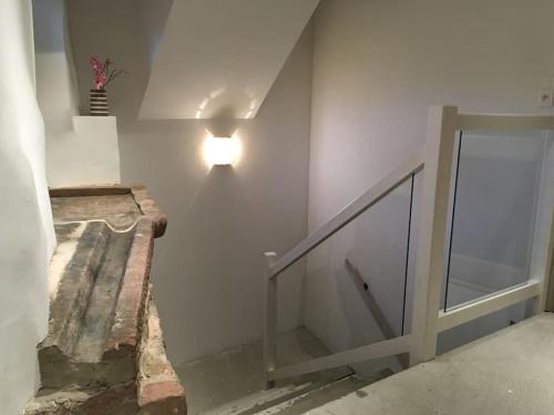 a staircase with a light on the wall and a glass door at Gîte La Tour des Remparts Pool & Jacuzzi in Saverne