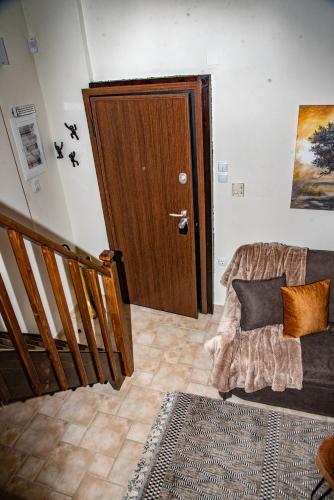 a living room with a wooden door and a couch at Serenity by Elite Dwellings in Portariá