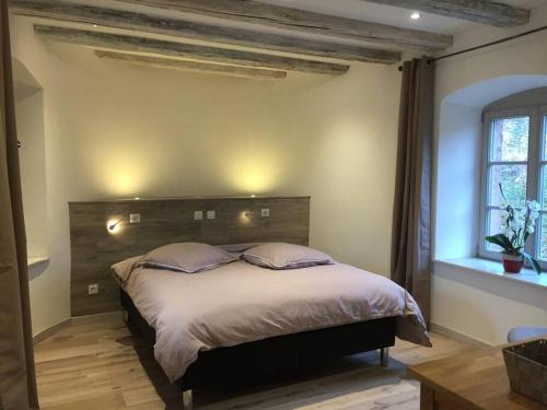 a bedroom with a large bed with two pillows at Gîte La Tour des Remparts Pool & Jacuzzi in Saverne
