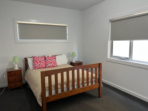 a bedroom with a crib and two windows at Sea Retreat - Esplanade Available Xmas 2023 and 2024 Summer in Robe