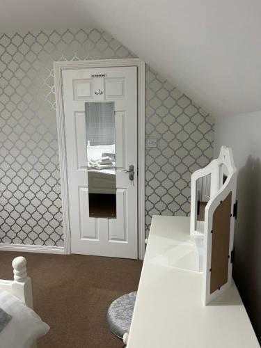 een kamer met een witte deur en een wit bureau bij Fair Green B&B in Ballygawley