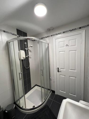 a shower with a glass door in a bathroom at Fair Green B&B in Ballygawley