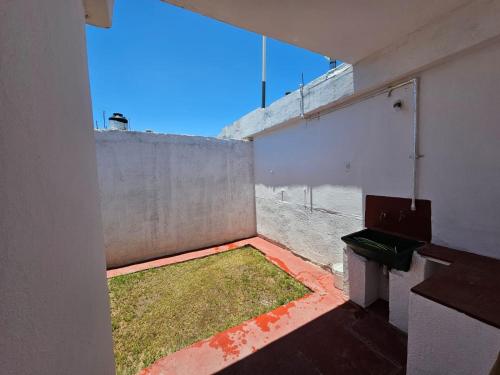 ein leeres Zimmer mit Fenster und Gras auf dem Boden in der Unterkunft Departamento zona norte in La Rioja