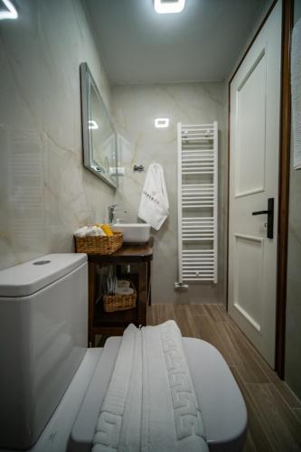 a bathroom with a white toilet and a sink at Serenity by Elite Dwellings in Portariá