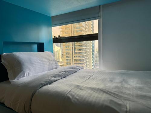 a bedroom with a bed and a large window at Living Room JBR in Dubai