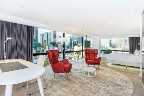 a living room with red chairs and a white table at NH Collection Mexico City Reforma in Mexico City