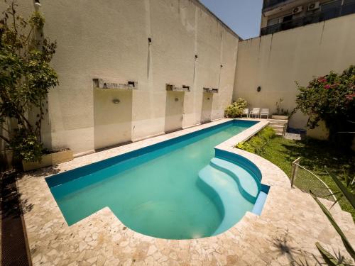 uma piscina com água azul num edifício em Rodex Casa Boutique - Paraíso céntrico con pileta, terraza, asador em San Miguel de Tucumán