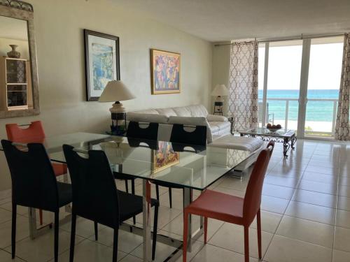 ein Wohnzimmer mit einem Glastisch und Stühlen in der Unterkunft Pavilion Beach Front Apartment with Balcony in Miami Beach