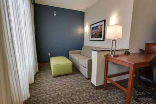 a living room with a couch and a desk in a hotel room at Drury Plaza Hotel Columbia East in Columbia