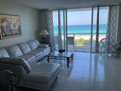 ein Wohnzimmer mit einem Sofa und Strandblick in der Unterkunft Pavilion Beach Front Apartment with Balcony in Miami Beach