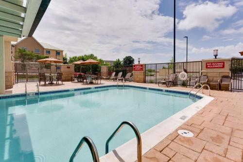a swimming pool at a hotel with tables and chairs at Drury Plaza Hotel Columbia East in Columbia