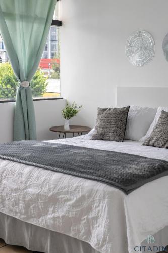 a bedroom with a large bed and a window at Hotel Citadin Zona 4 in Guatemala