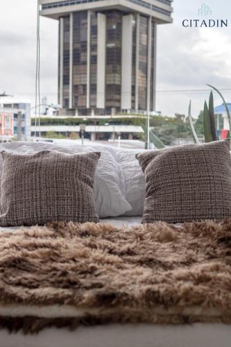 a bed with two pillows and a blanket at Hotel Citadin Zona 4 in Guatemala