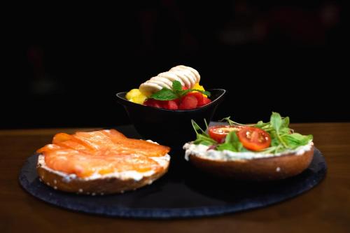 a plate with a sandwich and a bowl of fruit at Ventura Santa Teresa in Santa Teresa Beach