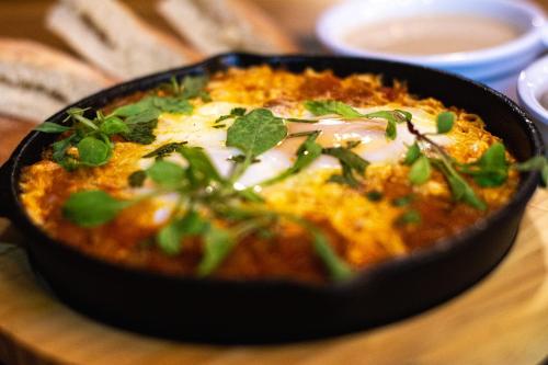 a black dish of food on a wooden table at Ventura Santa Teresa in Santa Teresa Beach