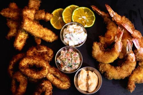 a plate of food with onion rings and dips at Ventura Santa Teresa in Santa Teresa Beach