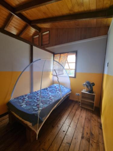 a bedroom with a bed with a metal bed frame at Painapaopao Backpacker in Moorea